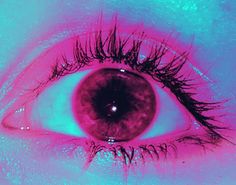 an eye with long eyelashes is shown in pink and blue light, as well as the iris