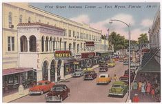 an old postcard shows cars driving down the street in front of hotels and businesses