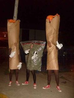 three people dressed up as birds holding bags