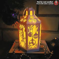 a lighted lantern sitting on top of a table next to a christmas ornament