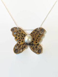 I love to try new things, and I love to do rivets on jewelry as an alternative to soldering pieces together. I have a pearl bezel set in sterling silver. A golden brass pierced butterfly is riveted onto a copper butterfly. I've used patina, which darkens the copper but does not have much effect on the brass, leaving it a shiny gold. Comes on a 16 inch sterling silver chain. Unique Handmade Butterfly Necklace, Handmade Butterfly-shaped Metal Jewelry, Handmade Butterfly Shaped Metal Jewelry, Artisan Butterfly-shaped Jewelry Gift, Nickel-free Butterfly Brass Jewelry, Nickel-free Brass Butterfly Jewelry, Unique Nickel Free Butterfly Necklace, Unique Nickel-free Butterfly Necklace, Amethyst Chakra