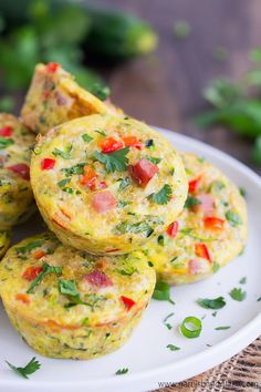 several small muffins on a white plate with parsley sprinkled around them