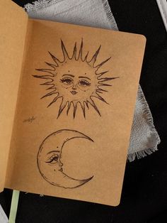 an open notebook with drawings of the sun and moon