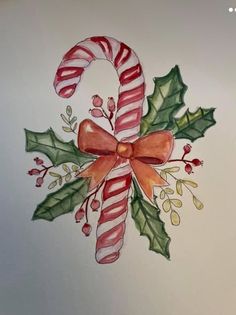 a watercolor drawing of a candy cane and holly