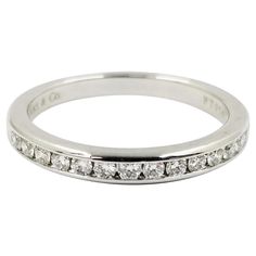 This classic diamond band is crafted in platinum by Tiffany & Co. It features 15 channel set round brilliant cut diamonds of F color and VVS clarity, approximately 0.25 carat total weight. The interior is stamped PT950. Finger size is currently 6; purchase includes free sizing (up or down 2 sizes). Professionally polished to remove scratches. Slight taper in ring design from 2.6mm on top to 2.2mm in the back. Channel Set Diamond Band, Round Diamond Band, Diamond Band Engagement Ring, Diamond Engagement Band, Diamond Band Ring, Band Engagement Ring, Tiffany And Co, Diamond Rings Bands, Channel Set