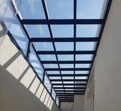 an empty hallway with glass roof and skylights on the ceiling is seen in this image