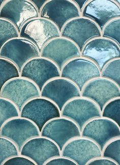 a close up view of a blue and green mosaic tile pattern with white circles on it