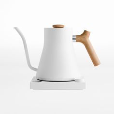 a white coffee pot with a wooden handle