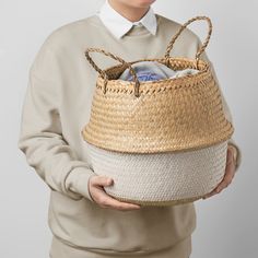 a person holding a basket with some items in it and smiling at the camera while wearing a white collared shirt