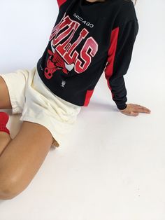 Our absolute favorite Chicago Bulls sweatshirt! Features the classic Chicago Bulls red coloring in the ribbed neckline and inner sleeves. The middle front of the sweatshirt showcases a beautiful print with the Chicago Bulls Logo. The perfect piece to pair with the AGOLDE 90's Pinch Waist Jean. 50% polyester 50% cotton Tag reads Official Licensed Product NBA - Made in USA Recommended for size xs-s, depending on the desired fit. Modeled on a small frame. Please refer to the measurements listed bel Chicago Bulls Sweatshirt, Chicago Bulls Logo, Bulls Logo, Vintage Chicago Bulls, Knit Outerwear, Tunic Sweatshirt, Line Shopping, Tank Top Camisole, Ribbed Neckline