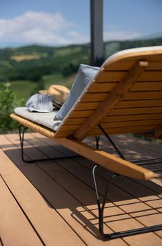 a wooden lounge chair sitting on top of a wooden deck