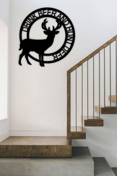 a metal deer is mounted to the side of a wall next to a stair case