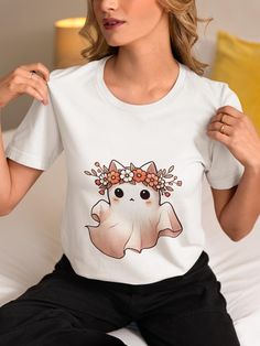 Get ready for spooky season with this adorable Floral Ghost Cat T-Shirt! Featuring a cute ghost cat adorned with a vibrant flower crown, this whimsical tee is perfect for Halloween and fall festivities. Made from high-quality materials, it's comfortable and stylish, making it a great addition to your seasonal wardrobe. Whether you're a cat lover or looking for a unique Halloween outfit, this shirt is sure to turn heads and spread smiles. Ideal for casual wear, parties, or as a fun gift for friends and family. Celebrate the spooky season in style! We utilize the authentic Bella Canvas 3001 brand, renowned for its UNISEX design, making it one of the most sought-after shirts in the market. Prior to placing an order, kindly refer to our size chart. It can be located in both the listing's image Kawaii Halloween Short Sleeve T-shirt, Kawaii Short Sleeve Halloween T-shirt, Kawaii Halloween Graphic Print Tops, White Cat Print T-shirt For Halloween, Cute White Tops For Halloween, Cute Halloween Cartoon Print T-shirt, Halloween White T-shirt With Cat Print, White T-shirt With Cat Design For Fall, White Cat Print T-shirt For Fall