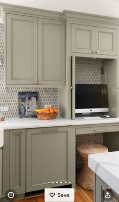 a kitchen with gray cabinets and white counter tops, along with a tv on the wall