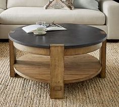 a living room with a couch, coffee table and pillows on the carpeted floor