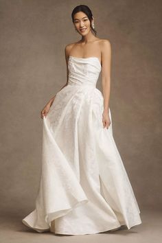 a woman in a white wedding dress posing for the camera with her hand on her hip