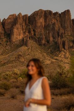 a woman standing in front of a mountain