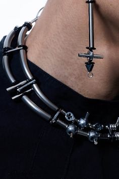 Experience the perfect fusion of futuristic aesthetics and industrial design with our Infiltrator Detachable Necklace. This unique necklace features an intricate chain composed of interconnected metal rings and spheres, creating a striking and modern look. The centerpiece is a detachable elongated pendant, adorned with small metal screws at each connection point, enhancing its industrial charm. This versatile pendant can be removed and worn as an earring, adding functionality to its bold style. Modern Gunmetal Metal Necklace, Modern Metal Chain Choker, Edgy Gunmetal Metal Jewelry, Futuristic Jewelry, Deconstructivism, Accessories Branding, Bold Fashion, Unique Necklaces, Sale Design