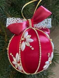 a red ornament hanging from a christmas tree