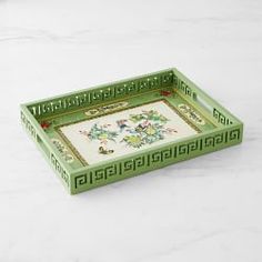 a green and white tray with designs on the bottom, sitting on a marble surface