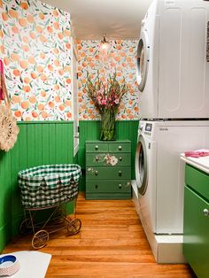 a washer and dryer in a small room with green wallpaper on the walls