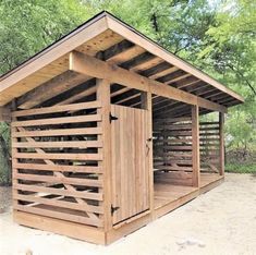 a wooden outhouse sitting in the middle of a forest