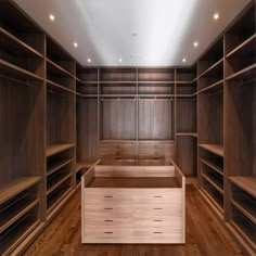 an empty walk - in closet with wooden shelves and drawers