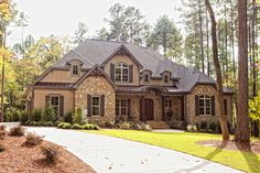 a large house with lots of windows in the front and side of it, surrounded by trees