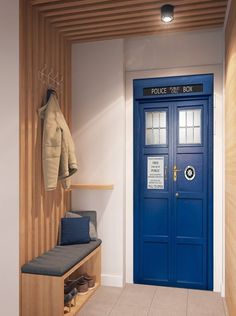 a blue police box sitting next to a coat rack on a wooden bench in front of a door