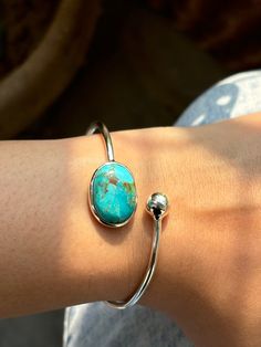 Elevate your jewelry collection with this stunning 925 sterling silver Turquoise Bangle. Each bangle is carefully crafted and features a 10x14mm oval Turquoise Gemstone, adding a touch of boho and bohemian style to any outfit. Turquoise has been prized for centuries for its deep, celestial blue color and is known as a symbol of royalty and honor, representing gods, power, spirit, and vision. It is also recognized as a universal symbol of wisdom and truth. Looking for a customized piece? We are h Oval Cuff Bracelet With Polished Finish As Gift, Elegant Oval Cabochon Cuff Bracelet, Elegant Turquoise Sterling Silver Oyster Bracelet, Adjustable Oval Sterling Silver Cuff Bracelet, Elegant Turquoise Oval Sterling Silver Bracelet, Sterling Silver Oval Gemstone Cuff Bracelet, Silver Oval Cuff Bracelet, Oval Sterling Silver Gemstone Cuff Bracelet, Oval Sterling Silver Cuff Bracelet Gift