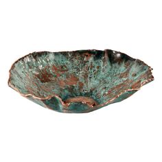 a green and brown bowl sitting on top of a white wall