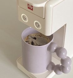 a coffee maker with a cup filled with liquid