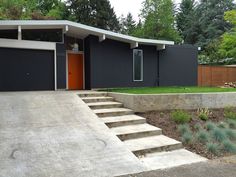 a modern house with two garages and steps leading up to the front door area