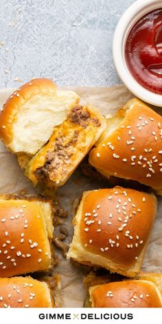 hamburger sliders on parchment paper with ketchup and mustard in the background text reads, gimme x delicious