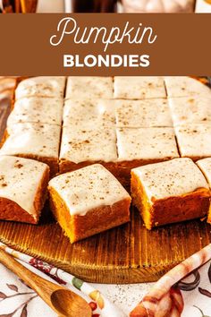 pumpkin blondies with white frosting on a cutting board