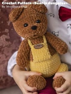 a small child holding a teddy bear in their hands with the caption crochet pattern bear in dunggaree