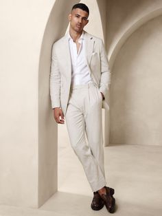 Designed with warm climates in mind, this sleek white suit is cut from an herringbone fabric that blends together soft cotton and luxurious linen.  Here, we left the jacket unlined through the back for even better breathability.  Tailored Slim Fit: More relaxed than our Slim Fit, this Italian cut style has a softer shoulder construction.  Notch lapel with 2-button front.  Four exterior pockets, three interior pockets.  Single back vent.  Lined sleeves, shoulders, and front body, unlined at back. Garden Party Attire, Italy Outfits Men, Linen Suit Men, Mens Linen Suit, Mens White Suit, Suit For Men Wedding, Linen Suits For Men, Cream Suit, Blazer Outfits Men