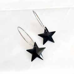 Elevate your jewelry collection with these stunning black Swarovski crystal star earrings. Featuring dazzling black crystal star pendants, each measuring 0.5" in height, these earrings exude sophistication and charm. The star pendants hang gracefully from sleek silver hoops, which add a modern touch to the design. With a total length of 1.5", these versatile earrings are perfect for both casual and formal occasions. Ideal for those who appreciate refined and eye-catching accessories, these black Black Star Charm Earrings, Black Star Charm Jewelry, Nickel-free Black Star Earrings, Black Star-shaped Nickel-free Earrings, Ring Sale, Crystal Stars, Star Pendant, Black Crystals, Silver Hoops