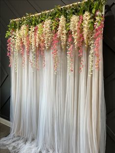 the flowers are hanging down from the ceiling in front of the curtained room divider