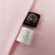 a pink shirt with a gold flower on the lapel and a black tie clip