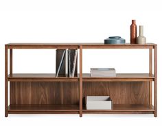 a wooden shelf with books and vases on it