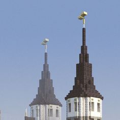 two tall buildings with clocks on them in front of a blue sky