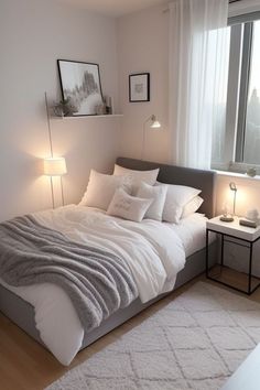 a bed with white sheets and pillows next to a window