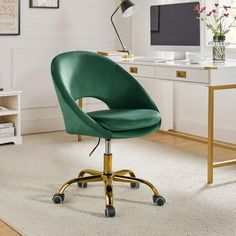 a green office chair sitting in front of a desk with a computer monitor on it