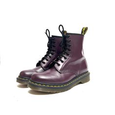 Vintage Y2K purple leather 8-eye 1460 lace up combat boots by Dr. Martens. Features dark purple leather uppers, rounded toe, 8-eye lace up fronts, combat style, above-ankle rise, flat tops, pull on loop at center back, classic yellow welt stitching, thick chunky sole, and short block heel. Excellent vintage condition.   Heel to toe (inside shoe): 9.625 inches  Ball of foot (bottom of sole): 4.125 inches  Heel height: 1.125 inches  Rise: 6.375 inches  Size 7 Purple Leather Lace-up Boots, Purple Lace-up Leather Boots, Purple Lace-up Boots For Streetwear, Purple Round Toe Boots For Streetwear, Combat Style, Inside Shoes, Lace Up Combat Boots, Purple Leather, Flats Top