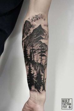 a man's arm with a mountain and trees tattoo on the left side of his arm