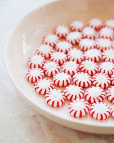 red and white candy canes are in a bowl