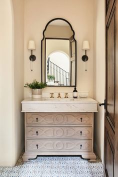 a bathroom with a sink, mirror and two lights on the wall next to it