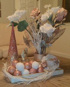 a vase filled with flowers sitting on top of a wooden table next to other decorations