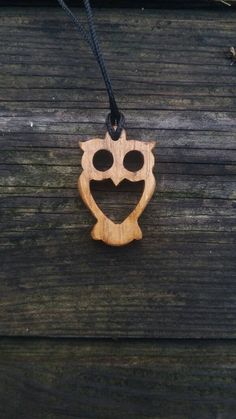 an owl wooden pendant on a black cord